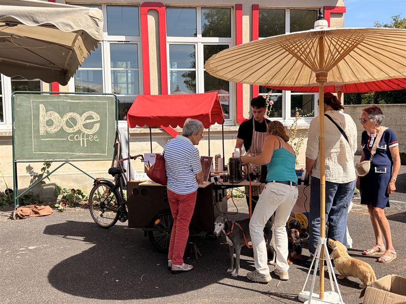 Vue d'ensemble du stand Boé Coffee sur un marché, ardoise et triporteur